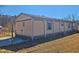 Back view of single-story home with neutral siding and brick foundation at 8025 Hebron Church Rd, Garner, NC 27529