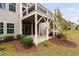 View of the two story rear exterior featuring upper level deck, lower patio, green grass, and landscaping at 832 Mountain Vista Ln, Cary, NC 27519