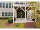 View of the two story rear exterior featuring upper level deck, lower patio, green grass, and landscaping at 832 Mountain Vista Ln, Cary, NC 27519