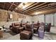 Unfinished basement space with concrete floor and exposed ceiling beams, featuring multiple brown leather recliners at 832 Mountain Vista Ln, Cary, NC 27519