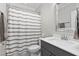 This bathroom features a gray vanity with modern fixtures, a white toilet, and a shower with a striped curtain at 832 Mountain Vista Ln, Cary, NC 27519