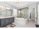 Bathroom featuring grey cabinets, soaker tub, tiled shower, and tile floors at 832 Mountain Vista Ln, Cary, NC 27519
