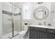 This bathroom features a shower with glass door, a window, and a grey vanity with white countertop at 832 Mountain Vista Ln, Cary, NC 27519