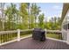 Outdoor wooden deck with black metal railing, offering a view of the backyard, plus a grill at 832 Mountain Vista Ln, Cary, NC 27519
