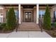 Close-up of the double door entrance with brick steps and small evergreens, and metal railings at 832 Mountain Vista Ln, Cary, NC 27519
