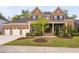 Charming brick home with a manicured lawn, three car garage, beautiful landscaping, and covered porch at 832 Mountain Vista Ln, Cary, NC 27519