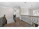 A hallway with wood floors, crown molding, wainscoting and black metal railing at 832 Mountain Vista Ln, Cary, NC 27519