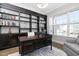 Bright office featuring a wall of custom dark wood shelving, hardwood floors, and ample natural light at 832 Mountain Vista Ln, Cary, NC 27519