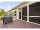 Outdoor patio with wooden floor, screened section and sliding glass doors to the home, plus a grill at 832 Mountain Vista Ln, Cary, NC 27519