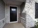 Close up of a front door framed by stylish stone and a 'Welcome' sign at 8630 Kenridge Ln, Fuquay Varina, NC 27526