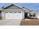 Attached two car garage with white door and stone veneer base on a home with gray siding at 8630 Kenridge Ln, Fuquay Varina, NC 27526