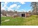 The backyard features a shed and a partial fence with the main house in the background under a bright blue sky at 902 Long Ave, Garner, NC 27529
