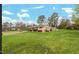 Cozy single story home with a lush green yard and mature trees under a bright blue partially cloudy sky at 902 Long Ave, Garner, NC 27529