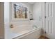 Bathroom with a large tub below a bright window with a serene view at 902 Loop Rd, Clayton, NC 27527
