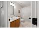 Bright bathroom with updated vanity, framed mirror and shower-tub combo with neutral tile flooring at 902 Loop Rd, Clayton, NC 27527