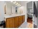 Bright bathroom featuring double sink vanity, neutral paint, and a doorway leading to the bedroom at 902 Loop Rd, Clayton, NC 27527