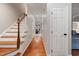 The hallway features wood floors and white trim leading to various rooms and a stairway with wood railing at 902 Loop Rd, Clayton, NC 27527