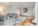Bright living room with hardwood floors, gray couches, and a decorative wall at 902 Loop Rd, Clayton, NC 27527