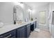 Elegant bathroom with dual sinks, shaker-style vanity, modern light fixtures, and a window at 992 Ambergate, Apex, NC 27502