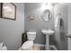 Charming powder room featuring pedestal sink, decorative mirror, and neutral paint at 992 Ambergate, Apex, NC 27502