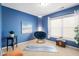 Bright bedroom featuring blue walls, a comfy chair, and natural light through the white blinds at 992 Ambergate, Apex, NC 27502