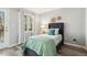 Cozy bedroom with a blue bed, window view, and a door to the outside at 100 Hunting Chase # 1-B, Cary, NC 27513