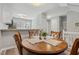 Cozy dining area with wood table and views into the updated kitchen and modern neutral tones at 100 Hunting Chase # 1-B, Cary, NC 27513
