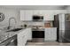 Modern kitchen boasts stainless steel appliances, granite countertops, and ample white cabinetry at 100 Hunting Chase # 1-B, Cary, NC 27513