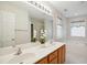 Bathroom featuring double sinks, a large mirror, and soaking tub with a window for natural light at 101 Whitney Ln, Durham, NC 27713