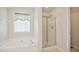 Well-lit bathroom with a soaking tub, a separate shower, and a window providing natural light at 101 Whitney Ln, Durham, NC 27713