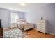 Bright bedroom features hardwood floors, a patterned rug, and a charming quilt on the bed at 101 Whitney Ln, Durham, NC 27713