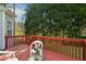 A red deck with white plastic patio furniture and a lovely view of trees and the lawn at 101 Whitney Ln, Durham, NC 27713
