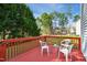 A red deck with white plastic patio furniture overlooking a lawn with trees at 101 Whitney Ln, Durham, NC 27713