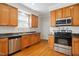 Functional kitchen with stainless steel appliances, wood cabinets, and ample lighting at 101 Whitney Ln, Durham, NC 27713