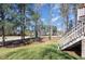 Well-maintained backyard with lush lawn, mature trees, and staircase leading to a deck, offering a serene outdoor space at 10841 Round Brook Cir, Raleigh, NC 27617