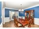 Formal dining room features wainscoting, large windows, hardwood floors, and a chandelier at 10841 Round Brook Cir, Raleigh, NC 27617