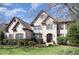 A charming two-story brick home showcases an arched entryway, manicured landscaping, and a well-kept lawn at 10841 Round Brook Cir, Raleigh, NC 27617