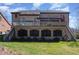 The back exterior shows a brick house with a deck, an enclosed area below, and a spacious backyard at 10841 Round Brook Cir, Raleigh, NC 27617