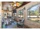 Relax on the screened porch with views of the golf course, brick flooring and elegant furniture at 10841 Round Brook Cir, Raleigh, NC 27617