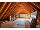 Unfinished attic space featuring exposed wooden beams and a window allowing for natural light at 12117 Cliffside Cir, Raleigh, NC 27614
