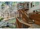 Exterior view of screened porch, wooden deck with stairs leading to a landscaped backyard and pond at 12117 Cliffside Cir, Raleigh, NC 27614