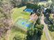 Large backyard features an in-ground pool, a tennis court and large lawn surrounded by mature trees at 12117 Cliffside Cir, Raleigh, NC 27614