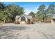 Elegant stone entrance with gated access, surrounded by mature trees, and features a sign displaying the community name at 12117 Cliffside Cir, Raleigh, NC 27614