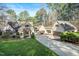 Charming home featuring a well-manicured lawn, mature trees, and a private driveway leading to a two-car garage at 12117 Cliffside Cir, Raleigh, NC 27614