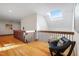 Bright hallway features hardwood floors, skylight, and a cozy chair at 12117 Cliffside Cir, Raleigh, NC 27614