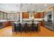 Well-lit kitchen features bar stool seating, modern pendant lights, stainless steel appliances, and tile backsplash at 12117 Cliffside Cir, Raleigh, NC 27614