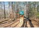 A backyard playground featuring a slide, swing, and climbing wall, perfect for Gathering fun in a natural setting at 12117 Cliffside Cir, Raleigh, NC 27614