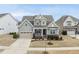 An aerial view of this charming two-story home showcases its manicured lawn, attached garage, and inviting curb appeal at 1212 Stonemill Falls Dr, Wake Forest, NC 27587