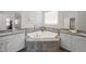 Bathroom features a soaking tub with tile surround and and vanities with granite counters at 1212 Stonemill Falls Dr, Wake Forest, NC 27587