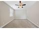 Cozy bedroom with neutral carpeting, a ceiling fan, and a window for natural light at 1212 Stonemill Falls Dr, Wake Forest, NC 27587
